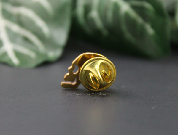 Rear view of a brass skull pin made by An American Metalsmith